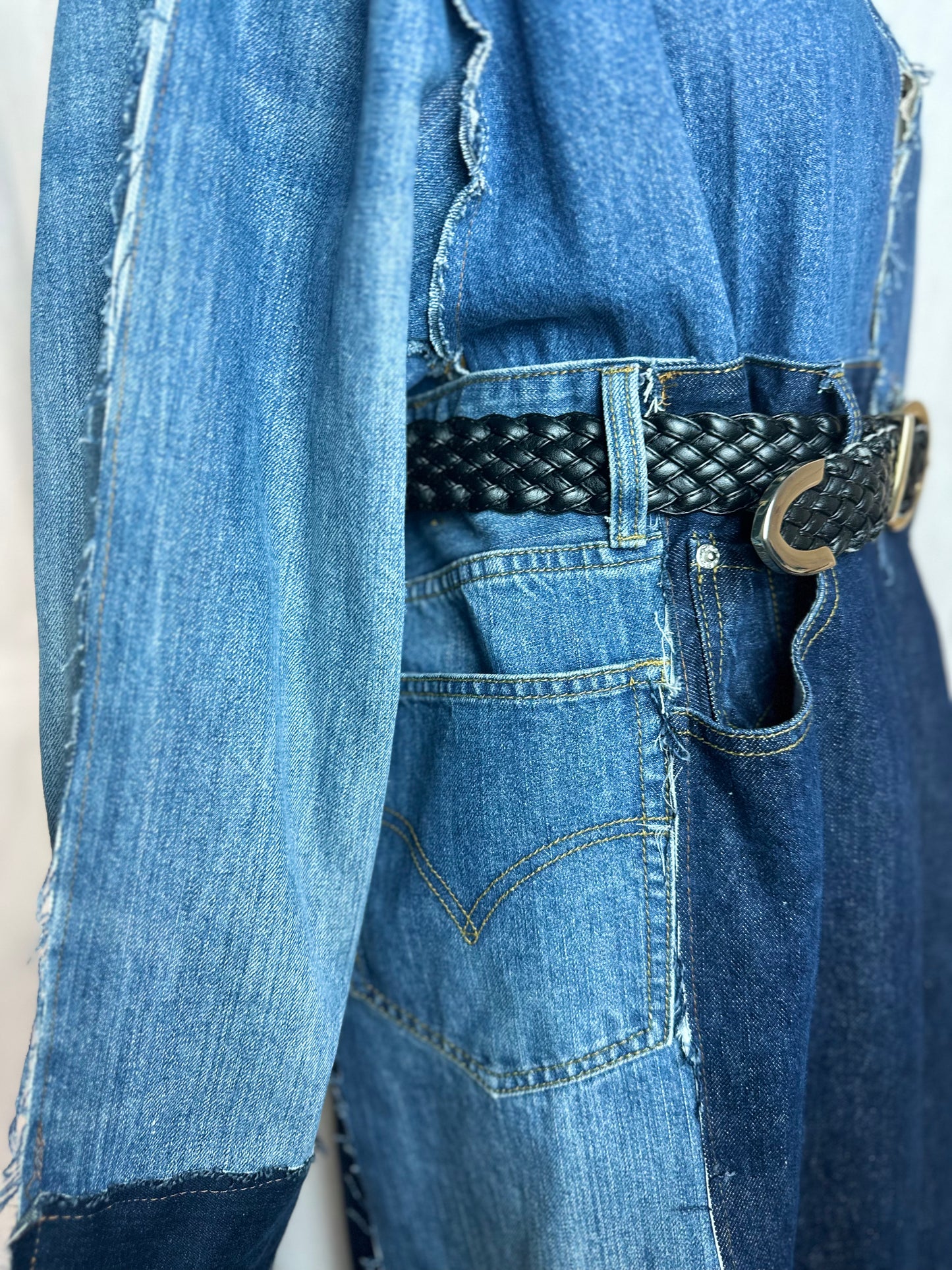 Long upcycled denim coat with frayed seams and macramé belt